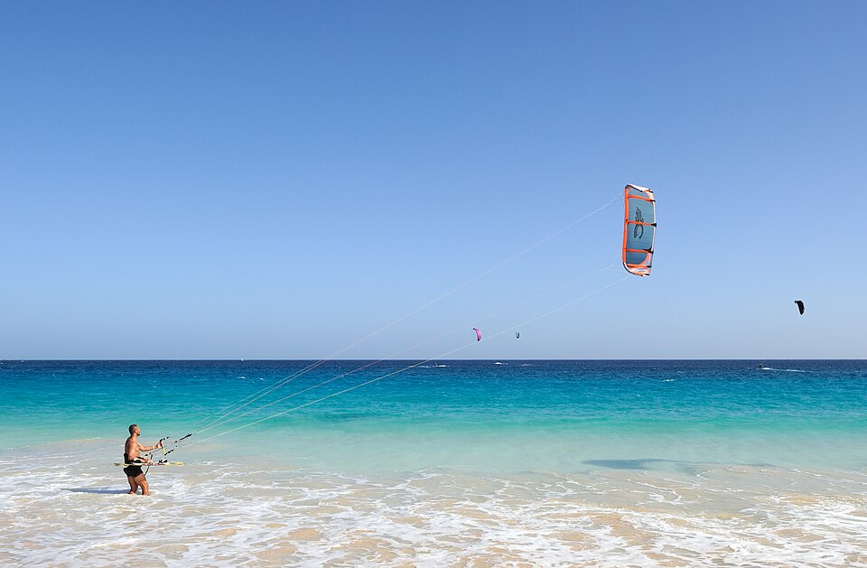Kite surfer gliding across tropical water